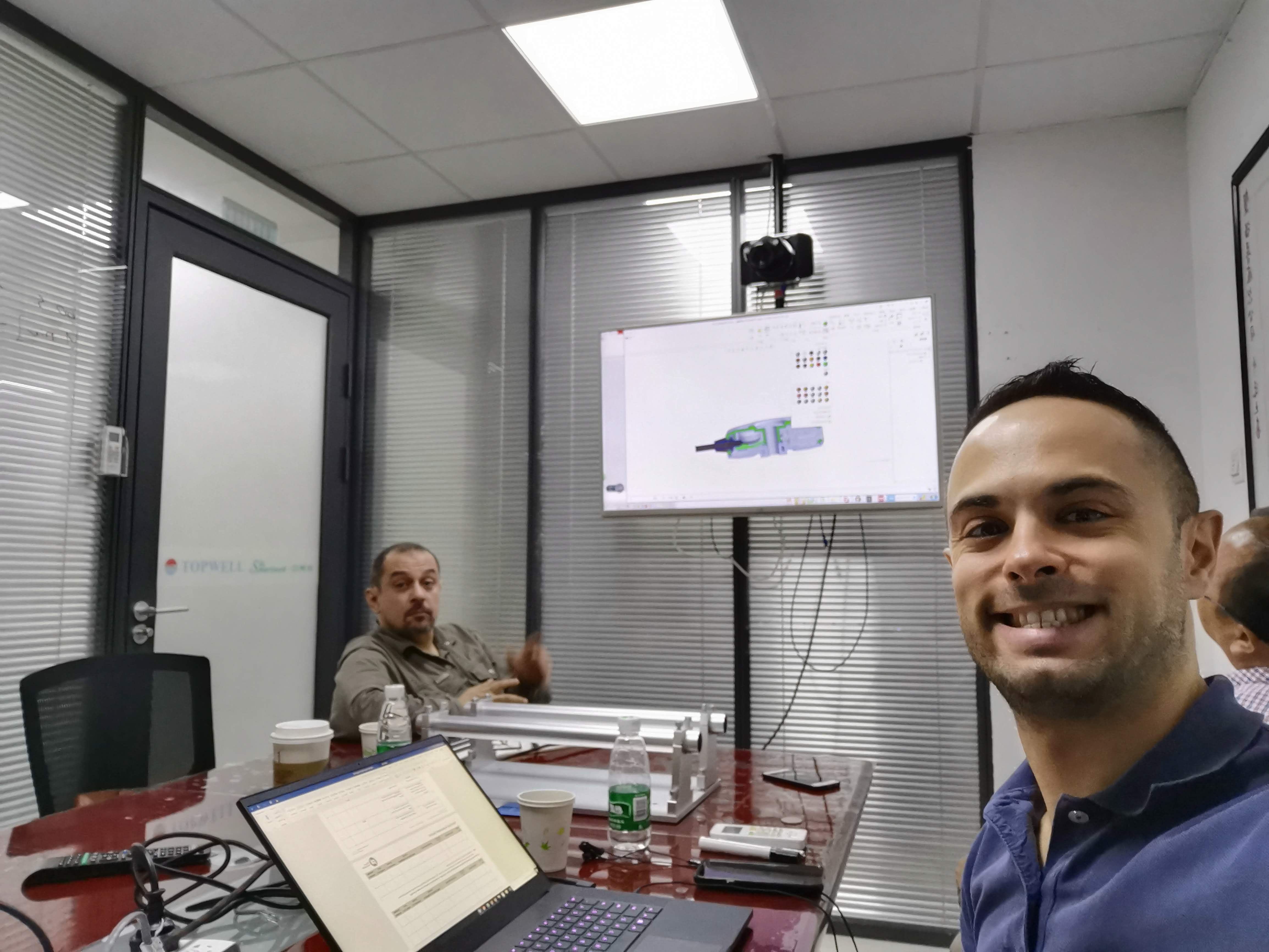 Design meeting with CAD on screen and physical components on the table